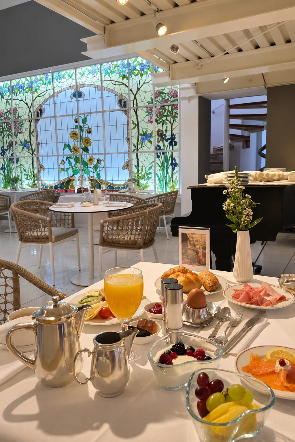 Frühstückstisch im Hotel Bamberger Hof mit Saft, Kaffee, Obst, Eiern, Brot und Schinken im sonnendurchfluteten Speisesaal.